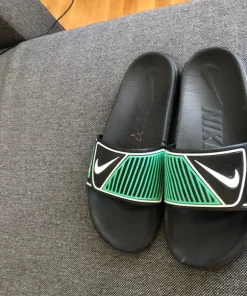 Black and green Nike slides
