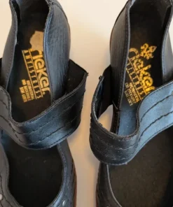 Svarta pumps med rem och nitdetaljer