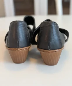 Svarta pumps med rem och nitdetaljer