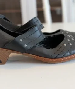 Svarta pumps med rem och nitdetaljer